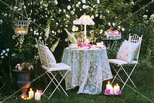 Abendlicher Tisch mit Stühlen im Rosengarten