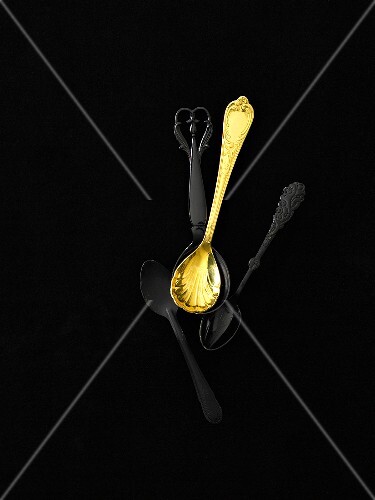 Three black spoons and one golden spoon