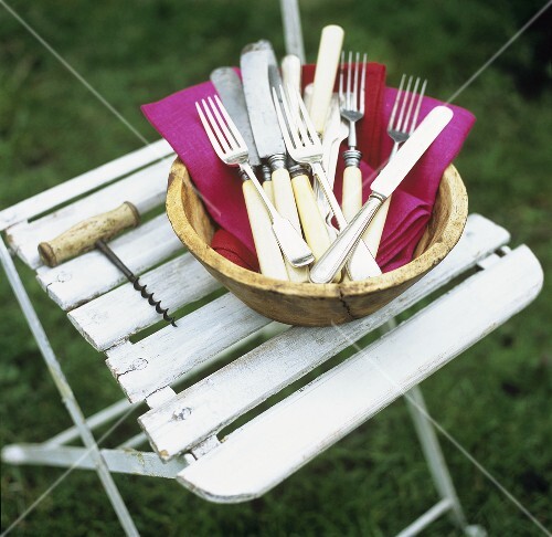 Corkscrew and bowl of napkins and cutlery on stool