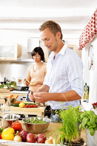 Young couple preparing vegetables in kitchen