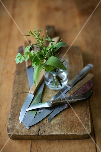 Kräutersträusschen & Küchenmesser auf Holzbrett