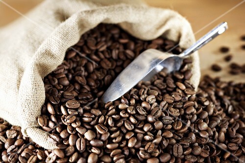 Geröstete Kaffeebohnen mit Jutesack und Schaufel