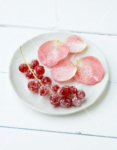 Rosenblütenblätter und Beeren mit Zucker bestreut