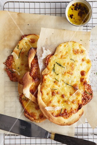 Cheese pizza (Pecorino) with basil on baking parchment