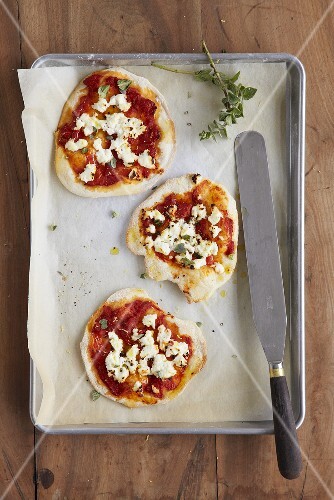 Minipizzen mit Tomaten, Ricotta und Oregano auf Backblech