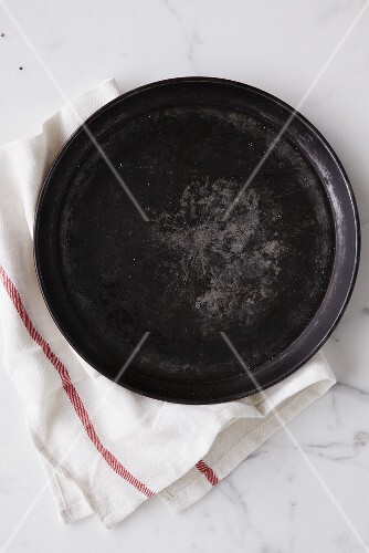 Rundes Kuchenblech auf Geschirrtuch (Draufsicht)
