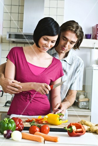 Man and woman chopping vegetables together
