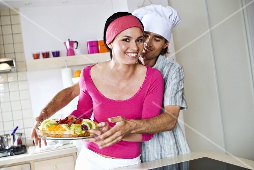 Man reaching for fruit tart in woman's hands