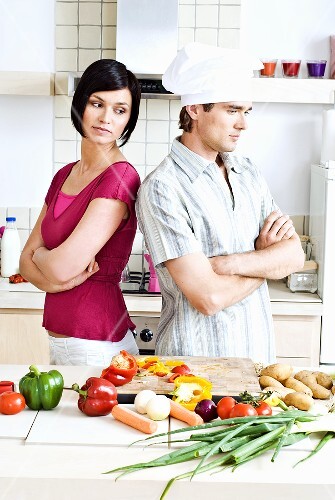 Discord in the kitchen: man & woman with their backs to eachother
