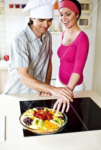 Man stopping woman stealing fruit from fruit tart