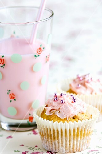 Fairy cakes with pink icing and a strawberry milkshake