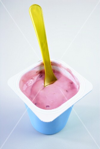 Erdbeerjoghurt mit gelbem Plastiklöffel