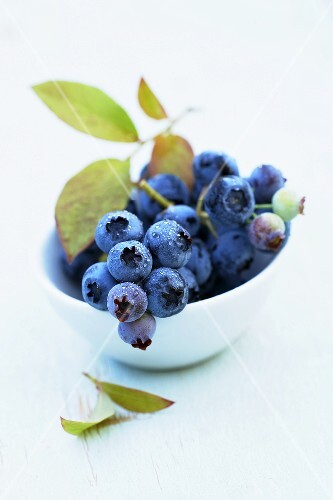 Blueberries with leaves in a small bowl