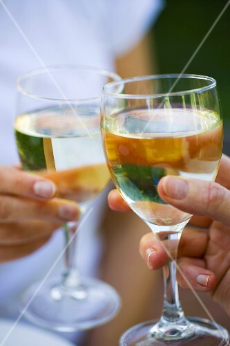 Clinking white wine glasses together