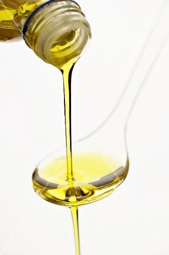 Pouring olive oil over a spoon