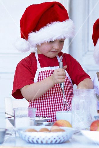 Kleines Mädchen mit Schneebesen beim Backen