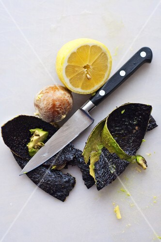 Reste einer Avocado mit Zitronenhälfte und Messer