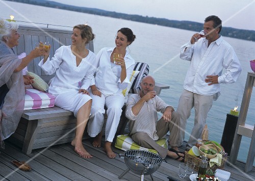 Mehrere Leute beim Grillen auf dem Steg