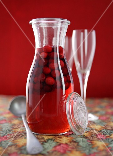 Home-made cranberry liqueur in a glass carafe