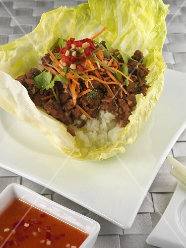 Mince on rice in a lettuce leaf with chilli sauce