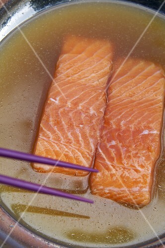 Two salmon fillets in fish stock