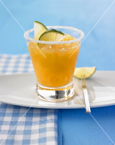 A glass of frozen peach daiquiri with sugared rim