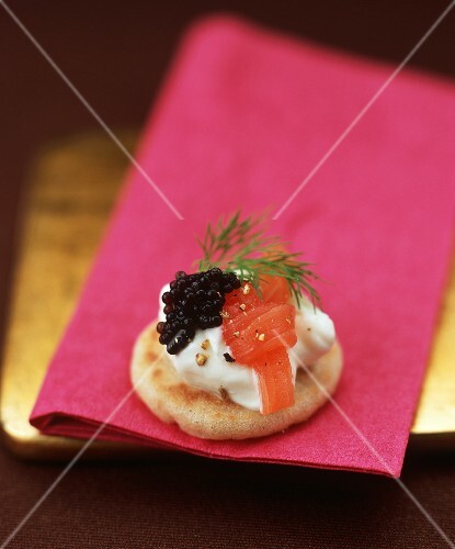 Small blini topped with creamed horseradish, smoked salmon and caviar