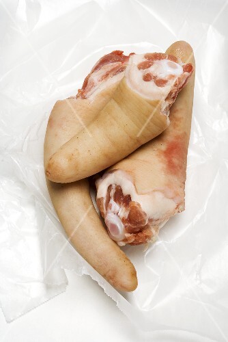 Three pigs' tails on plastic wrap