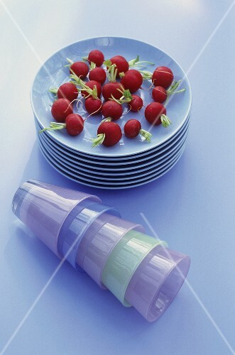 Fresh radishes and partyware (plates, tumblers)