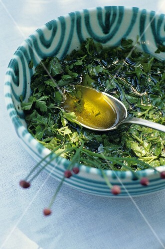 A small dish of oil with fresh herbs