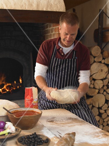 Pizza baker kneading dough
