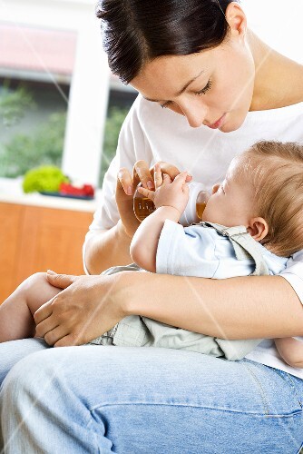 Baby trinkt Tee aus der Flasche