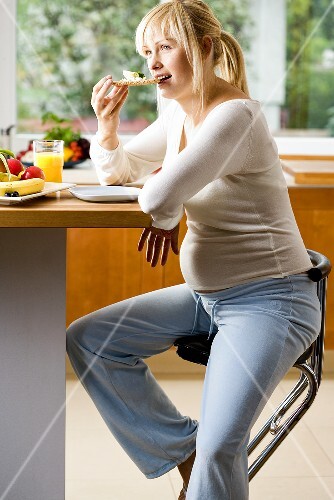 Pregnant woman having breakfast