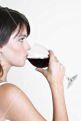 Young woman drinking a glass of red wine