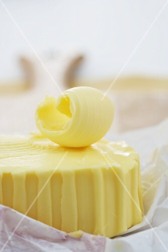 Butter curl on block of butter (close-up)