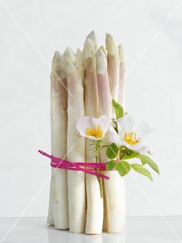A bunch of asparagus with dog roses