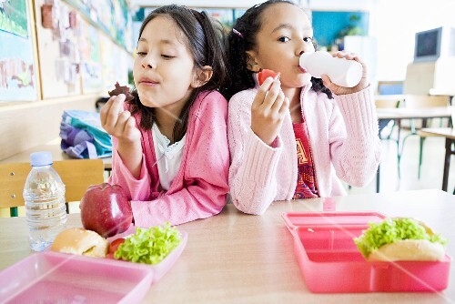 Two girls eating lunch at school
