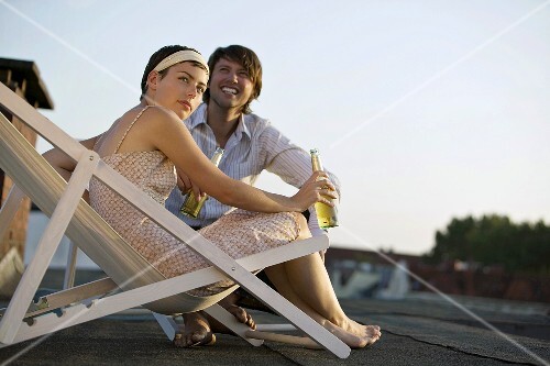 Young couple with drinks on a roof terrace
