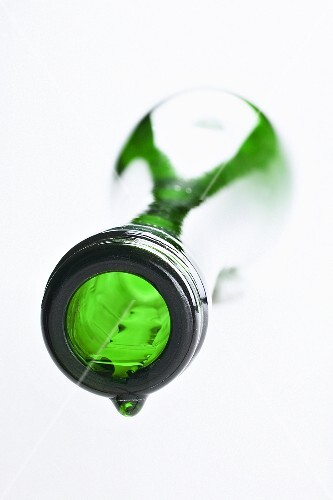White wine bottle, lying on its side, with a drop of wine