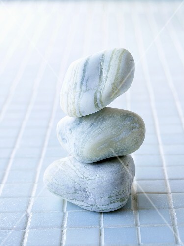 Three stones on pale blue tiles