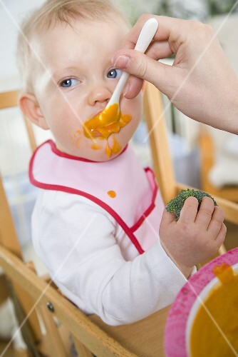 Small child being fed baby food
