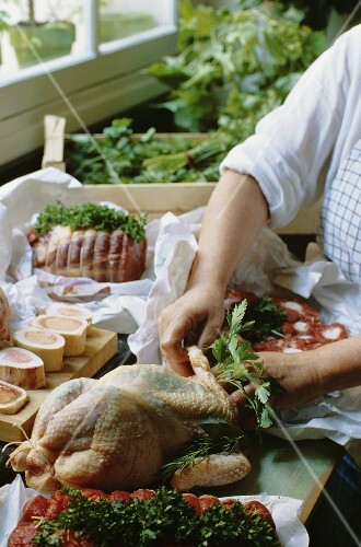 Stuffing a chicken with herbs