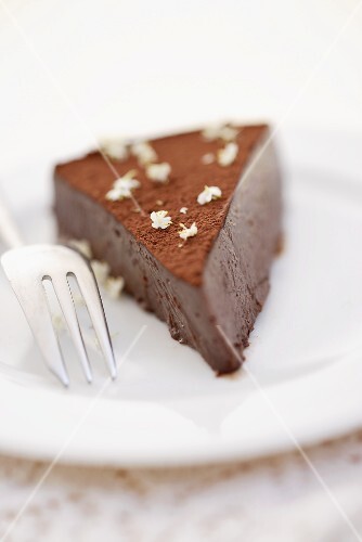 Ein Stück Schokotrüffeltorte mit Holunderblüten