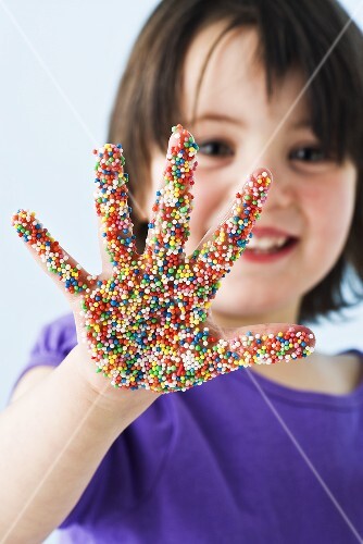 Girl with her hand covered in sprinkles