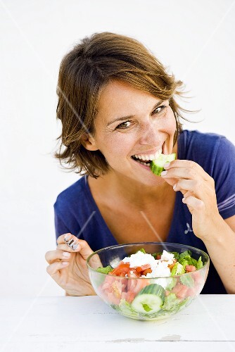 Young woman eating salad