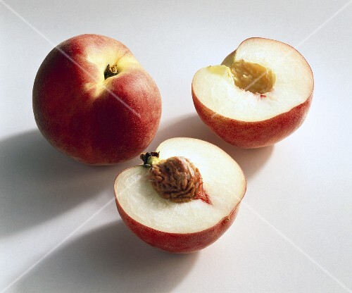 Ganzer und halbierter Pfirsich der Sorte Fidelia