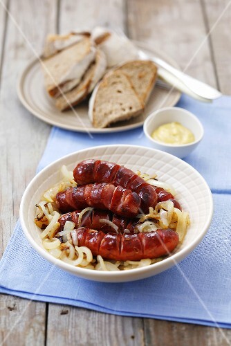 Sausages on onions with bread and mustard
