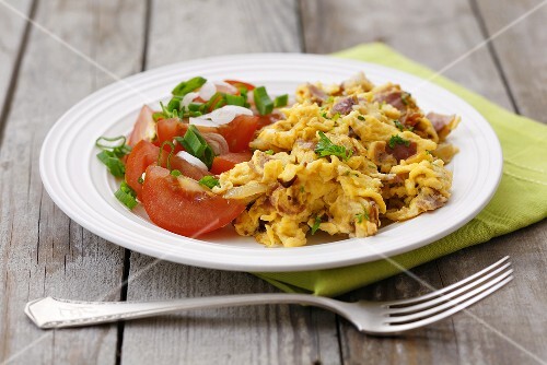 Scrambled egg with ham, parsley and tomato salad