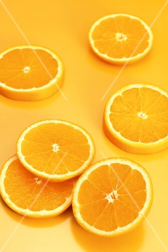 Several orange slices on orange background