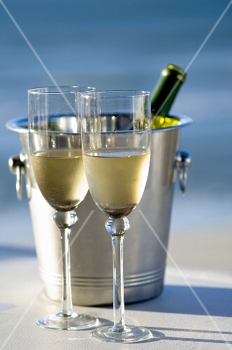 Two glasses of white wine with bottle in wine cooler